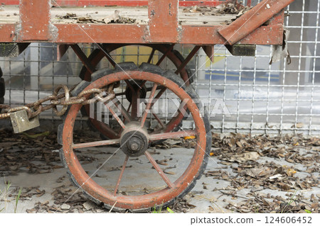Old handcart fasten by chain and lock beside street Old handcart fasten by chain and lock beside street 124606452