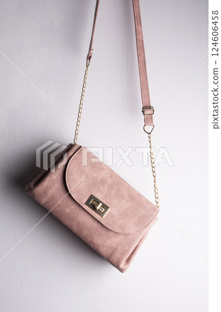 Women stylish leather handbag in front of white wall Women stylish leather handbag in front of white wall 124606458