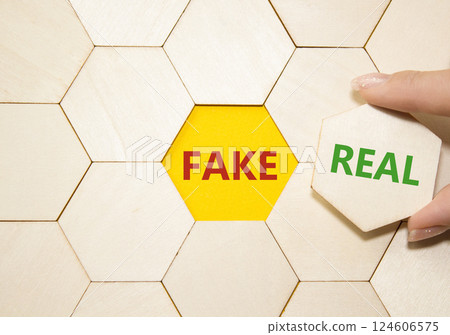 Real or Fake symbol. Concept word Real or Fake on wooden puzzle. Businessman hand. Beautiful yellow background. Business and Real or Fake concept. Copy space 124606575