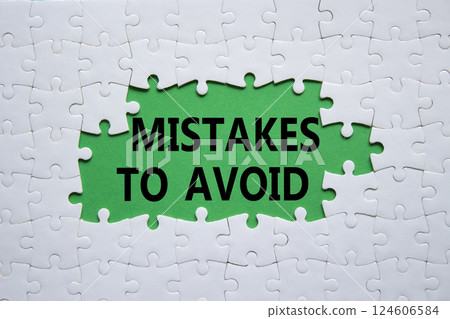 Mistakes symbol. Concept words Mistakes to Avoid on white puzzle. Beautiful green background Business and Mistakes to Avoid concept. Copy space. 124606584
