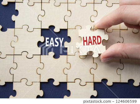 Easy or Hard symbol. Concept word Easy or Hard on wooden puzzle. Businessman hand. Beautiful deep blue background. Business and Easy or Hard concept. Copy space 124606599