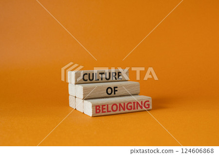Culture of Belonging symbol. Wooden blocks with words Culture of Belonging. Beautiful orange background. Business and Culture of Belonging concept. Copy space. 124606868