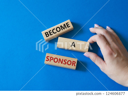 Become a sponsor symbol. Concept word Become a sponsor on wooden blocks. Businessman hand. Beautiful blue background. Business and Become a sponsor concept. Copy space 124606877