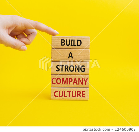 Company culture symbol. Wooden blocks with words Build a strong company culture. Businessman hand. Beautiful yellow background. Business and Company culture concept. Copy space. Company culture symbol. Wooden blocks with words Build a strong company culture. Businessman hand. Beautiful yellow background. Business and Company culture concept. Copy space. 124606902