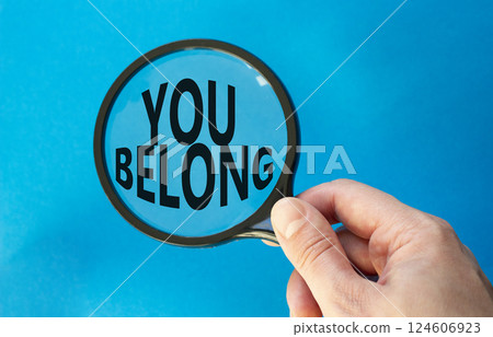 You belong symbol. Concept words You belong on magnifying glass. Beautiful blue background. Businessman hand. Business and You belong concept. Copy space. 124606923