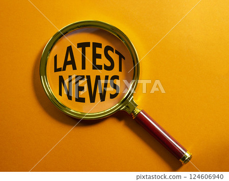 Latest News symbol. Concept word Latest News on magnifying glass. Beautiful orange background. Business and Latest News concept. Copy space 124606940