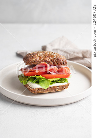 Toast sandwich made of grain bread with prosciutto, cheese, tomatoes, lettuce and sauce on a plate Toast sandwich made of grain bread with prosciutto, cheese, tomatoes, lettuce and sauce on a plate 124607328