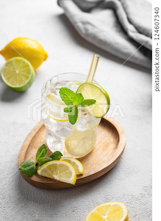 Cocktail or lemonade mojito with fresh lemon, lime, mint and ice on a wooden plate  124607340