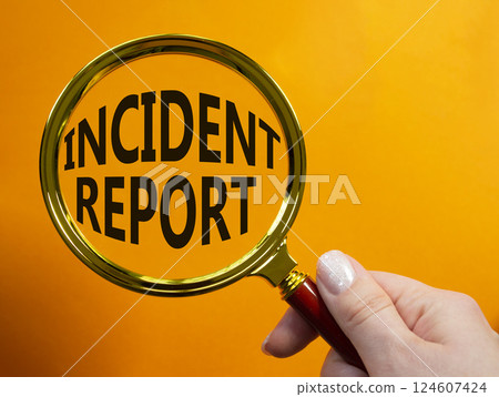 Incident Report symbol. Concept word Incident Report on magnifying glass. Businessman hand. Beautiful orange background. Business and Incident Report concept. Copy space Incident Report symbol. Concept word Incident Report on magnifying glass. Businessman hand. Beautiful orange background. Business and Incident Report concept. Copy space 124607424