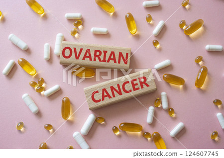 Ovarian Cancer symbol. Concept word Ovarian Cancer on wooden blocks. Beautiful pink background with pills. Medicine and Ovarian Cancer concept. Copy space 124607745