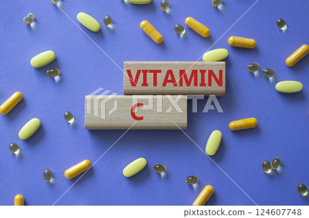Vitamin C symbol. Concept word Vitamin C on wooden blocks. Beautiful purple background with pills. Medicine and Vitamin C concept. Copy space 124607748