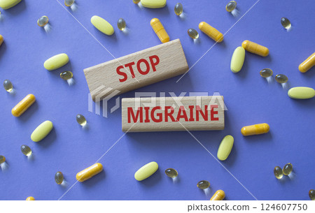 Stop Migraine symbol. Concept word Stop Migraine on wooden blocks. Beautiful purple background with pills. Medicine and Stop Migraine concept. Copy space 124607750