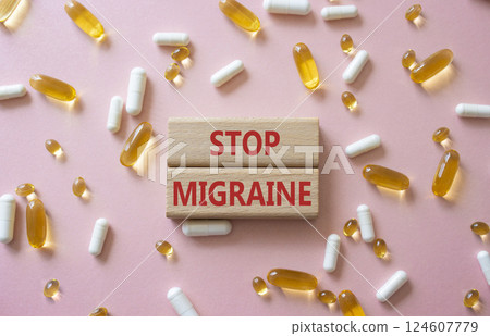 Stop Migraine symbol. Concept word Stop Migraine on wooden blocks. Beautiful pink background with pills. Medicine and Stop Migraine concept. Copy space 124607779