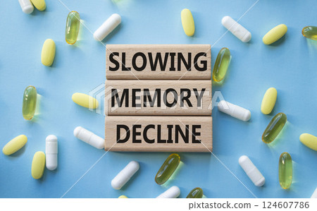Slowing Memory Decline symbol. Concept words Slowing Memory Decline on wooden blocks. Beautiful blue background with pills. Healthcare and Slowing Memory Decline concept. Copy space. 124607786