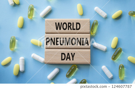 Medicine symbol. Concept words World Pneumonia Day on wooden blocks. Beautiful blue background with pills. Medicine concept and World Pneumonia Day. Copy space 124607787