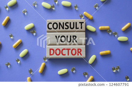 Consult Your Doctor symbol. Concept word Consult Your Doctor on wooden blocks. Beautiful purple background with pills. Medicine and Consult Your Doctor concept. Copy space Consult Your Doctor symbol. Concept word Consult Your Doctor on wooden blocks. Beautiful purple background with pills. Medicine and Consult Your Doctor concept. Copy space 124607791