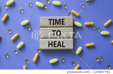 Medicine symbol. Concept words Time to Heal on wooden blocks. Beautiful purple background with pills. Medicine concept and Time to Heal. Copy space Medicine symbol. Concept words Time to Heal on wooden blocks. Beautiful purple background with pills. Medicine concept and Time to Heal. Copy space 124607792