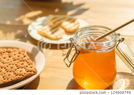 Honey Jar on a Wooden Table With Cookies in Soft Afternoon Light, Evoking Cafes and Bakeries Honey Jar on a Wooden Table With Cookies in Soft Afternoon Light, Evoking Cafes and Bakeries 124608749