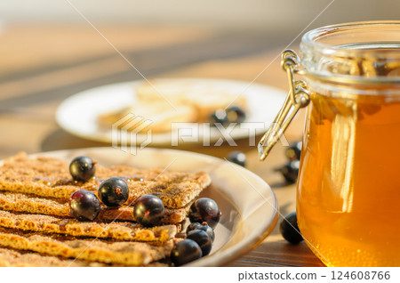 Crackers Topped With Berries and Honey on a Rustic Table, Highlighting an Inviting Gourmet Snack for Catering and Food Blogs 124608766