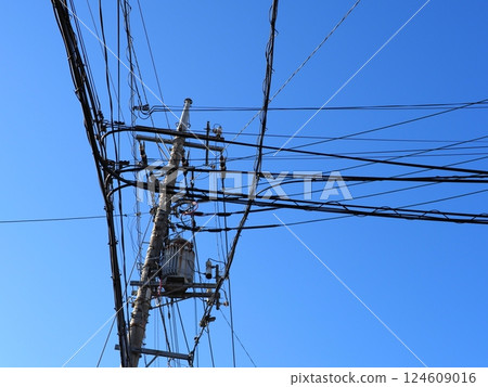 A tower towering in the blue sky, clear sky and electric poles, copy space A tower towering in the blue sky, clear sky and electric poles, copy space 124609016