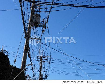 A tower towering in the blue sky, clear sky and electric poles, copy space A tower towering in the blue sky, clear sky and electric poles, copy space 124609021