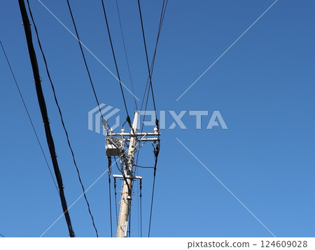 A tower towering in the blue sky, clear sky and electric poles, copy space 124609028