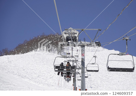 晴朗天氣下的滑雪勝地：通往山頂的纜車和純白的山坡 124609357