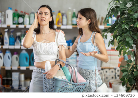 Tired mother and demanding daughter in supermarket cleaning aisle Tired mother and demanding daughter in supermarket cleaning aisle 124609720