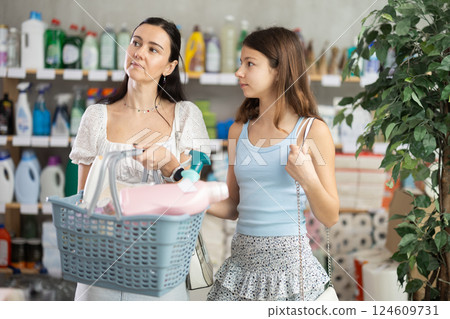 Woman with daughter choosing household chemicals in store Woman with daughter choosing household chemicals in store 124609731