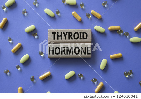 Thyroid Hormone symbol. Concept word Thyroid Hormone on wooden blocks. Beautiful purple background with pills. Medicine and Thyroid Hormone concept. Copy space Thyroid Hormone symbol. Concept word Thyroid Hormone on wooden blocks. Beautiful purple background with pills. Medicine and Thyroid Hormone concept. Copy space 124610041