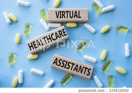 Medicine symbol. Concept words Virtual Healthcare Assistants on wooden blocks. Beautiful blue background with pills. Medicine concept and Virtual Healthcare Assistants. Copy space Medicine symbol. Concept words Virtual Healthcare Assistants on wooden blocks. Beautiful blue background with pills. Medicine concept and Virtual Healthcare Assistants. Copy space 124610092