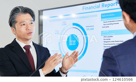 A group of middle-aged male business people having a meeting while looking at a large screen monitor 124610566