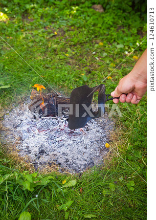 Burning fire in the evening, summer beautiful warm evening. The process of lighting a fire. 124610713