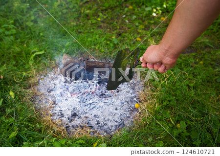 Burning fire in the evening, summer beautiful warm evening. The process of lighting a fire. 124610721