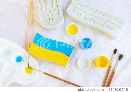 Artistic process of painting the Ukrainian flag with blue and yellow colors using brushes and paint palette Artistic process of painting the Ukrainian flag with blue and yellow colors using brushes and paint palette 124610746