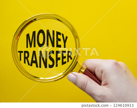 Money Transfer symbol. Magnifying Glass with Concept word Money Transfer. Businessman hand. Beautiful yellow background. Business and Money Transfer concept. Copy space Money Transfer symbol. Magnifying Glass with Concept word Money Transfer. Businessman hand. Beautiful yellow background. Business and Money Transfer concept. Copy space 124610913