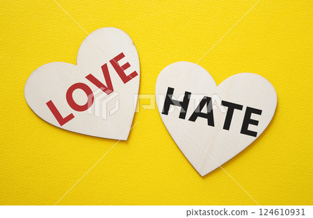 Love vs Hate symbol. Concept word Love vs Hate on wooden hearts. Beautiful yellow background. Business and Love vs Hate concept. Copy space Love vs Hate symbol. Concept word Love vs Hate on wooden hearts. Beautiful yellow background. Business and Love vs Hate concept. Copy space 124610931