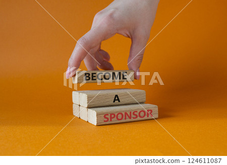 Become a sponsor symbol. Concept word Become a sponsor on wooden blocks. Businessman hand. Beautiful orange background. Business and Become a sponsor concept. Copy space 124611087