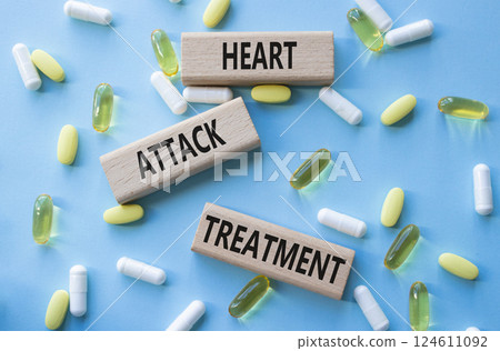 Heart Attack Treatment symbol. Concept word Heart Attack Treatment on wooden blocks. Beautiful blue background with pills. Medicine and Heart Attack Treatment concept. Copy space 124611092