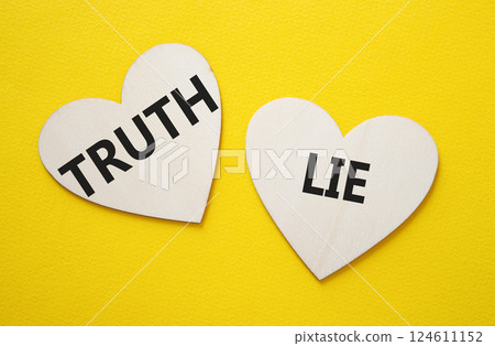 Truth or Lie symbol. Concept word Truth or Lie on wooden hearts. Beautiful yellow background. Business and Truth or Lie concept. Copy space 124611152