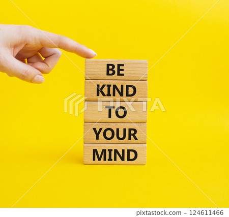 Be kind to your Mind symbol. Wooden blocks with words Be kind to your Mind. Businessman hand. Beautiful yellow background. Business and Be kind to your Mind concept. Copy space. 124611466