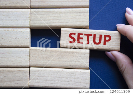 Setup symbol. Wooden blocks with word Setup. Businessman hand. Beautiful deep blue background. Setup concept. Copy space. Setup symbol. Wooden blocks with word Setup. Businessman hand. Beautiful deep blue background. Setup concept. Copy space. 124611509