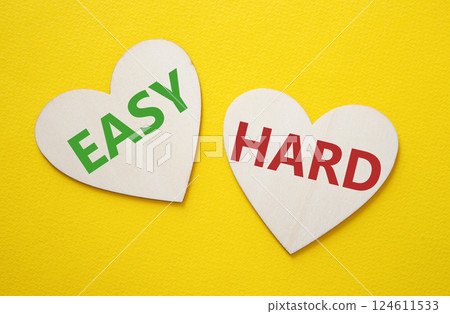 Easy or Hard symbol. Concept word Easy or Hard on wooden hearts. Beautiful yellow background. Business and Easy or Hard concept. Copy space 124611533