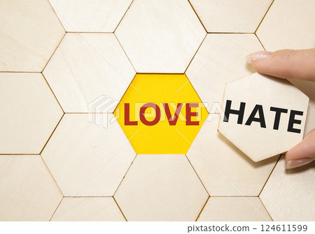 Love vs Hate symbol. Concept word Love vs Hate on wooden puzzle. Businessman hand. Beautiful yellow background. Business and Love vs Hate concept. Copy space Love vs Hate symbol. Concept word Love vs Hate on wooden puzzle. Businessman hand. Beautiful yellow background. Business and Love vs Hate concept. Copy space 124611599