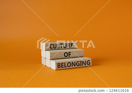 Culture of Belonging symbol. Wooden blocks with words Culture of Belonging. Beautiful orange background. Business and Culture of Belonging concept. Copy space. 124611616