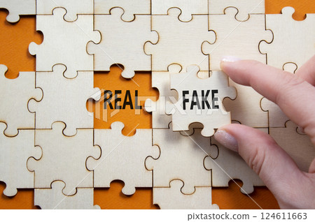 Real or Fake symbol. Concept word Real or Fake on wooden blocks. Businessman hand. Beautiful orange background. Business and Real or Fake concept. Copy space Real or Fake symbol. Concept word Real or Fake on wooden blocks. Businessman hand. Beautiful orange background. Business and Real or Fake concept. Copy space 124611663