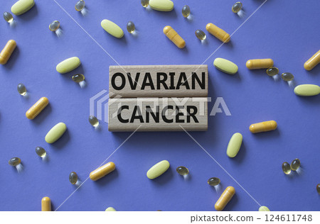 Ovarian Cancer symbol. Concept word Ovarian Cancer on wooden blocks. Beautiful purple background with pills. Medicine and Ovarian Cancer concept. Copy space 124611748