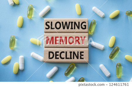 Slowing Memory Decline symbol. Concept words Slowing Memory Decline on wooden blocks. Beautiful blue background with pills. Healthcare and Slowing Memory Decline concept. Copy space. 124611761