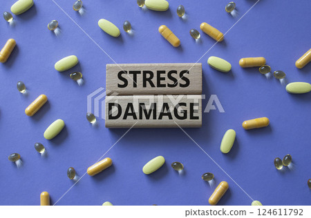 Stress Damage symbol. Concept word Stress Damage on wooden blocks. Beautiful purple background with pills. Medicine and Stress Damage concept. Copy space 124611792