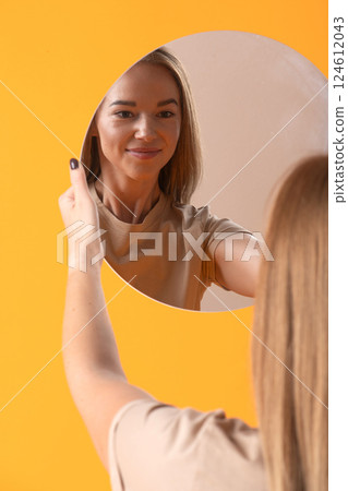 Woman Looking at Reflection in Round Mirror Woman Looking at Reflection in Round Mirror 124612043